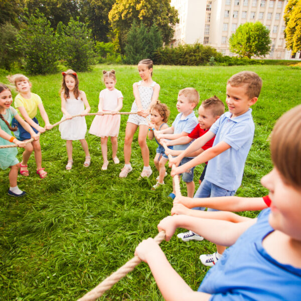 Children of all ages form a rope circle outdoors. Concept of sports games